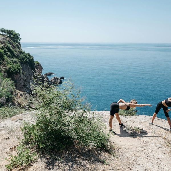 A person stretching outdoors during sunrise, feeling energetic and refreshed.